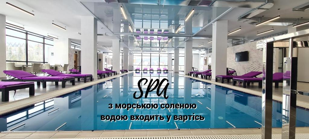 a swimming pool with purple chairs in a building at Kasimir Hotel & SPA in Bukovel