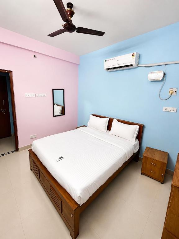 a bedroom with a bed with a ceiling fan at The grand chateau in Singapperumālkovil