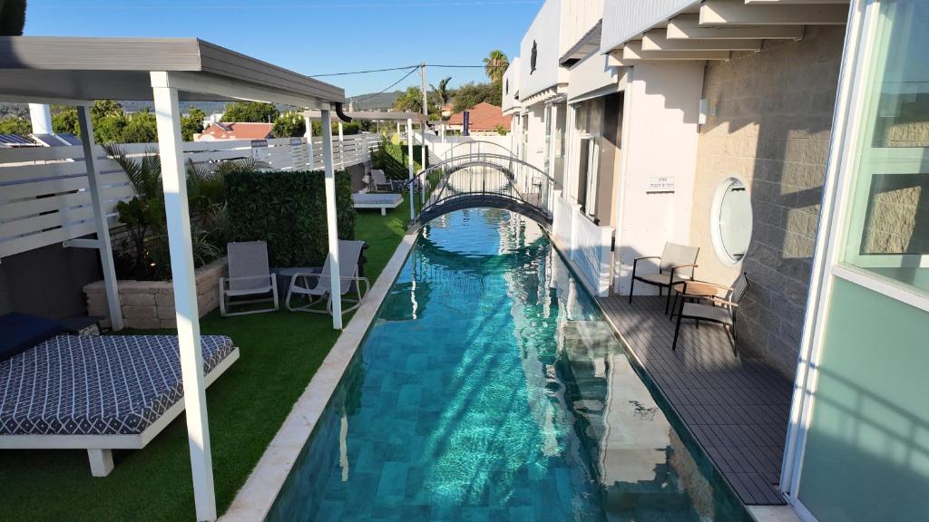 a view of a swimming pool with a bridge at אחוזת מיא - סוויטות בוטיק על המים in Goren