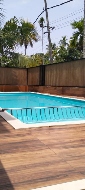 Ein Schwimmbecken mit blauen Stühlen neben einem Zaun in der Unterkunft Bachan's Casa The Private Pool Villa Cherai in Cherai Beach