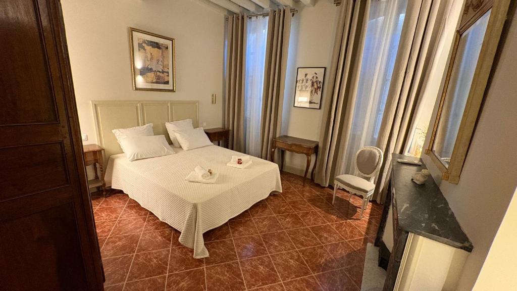 a bedroom with a white bed in a room at Le charme de l'Arlésienne in Arles