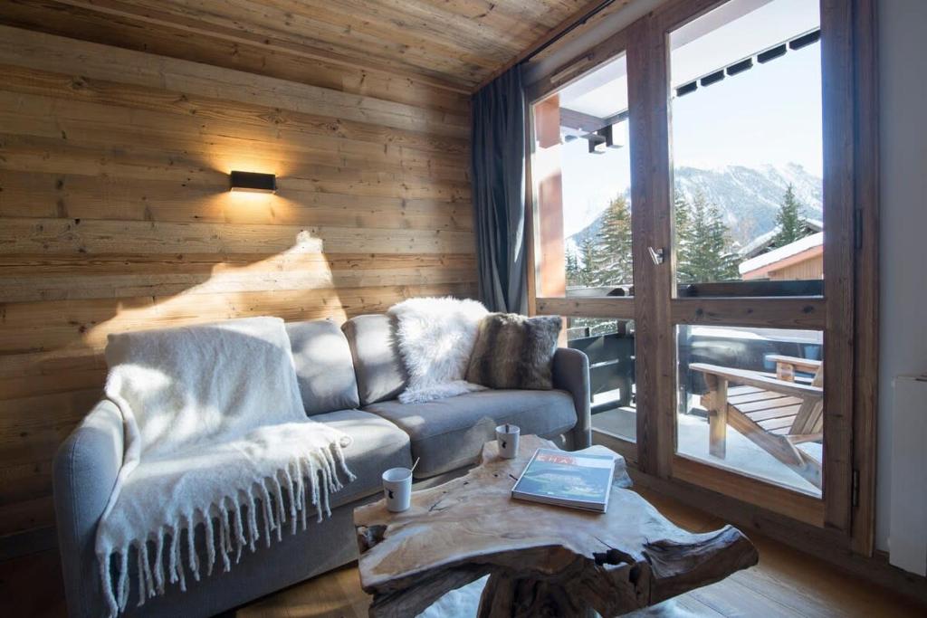 a living room with a couch and a large window at Les Brigues - Appartement avec vue sur la montagne et accès aux pistes in Courchevel