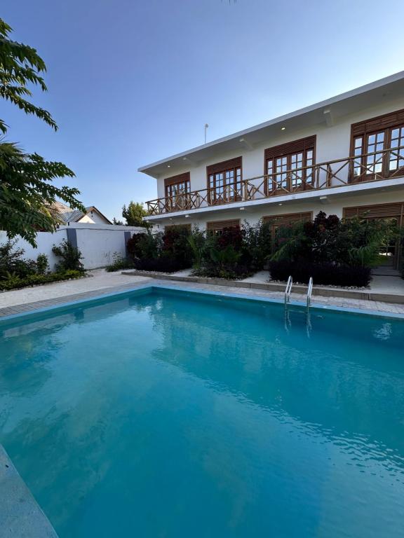 a large swimming pool in front of a building at Cheff Hotel Vianuel in Kendwa