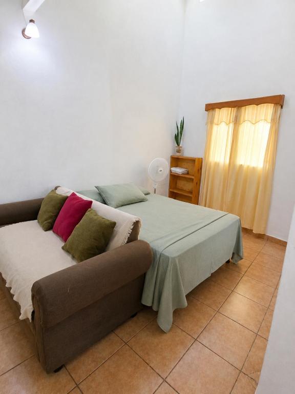 a bedroom with a bed and a couch and a window at Estudio Privado, WiFi, A 7 min de Palmerola in Comayagua