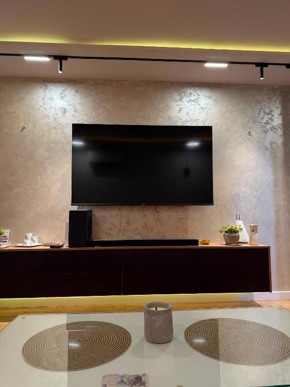 a living room with a large flat screen tv on a wall at Ines Apartment in Sarajevo