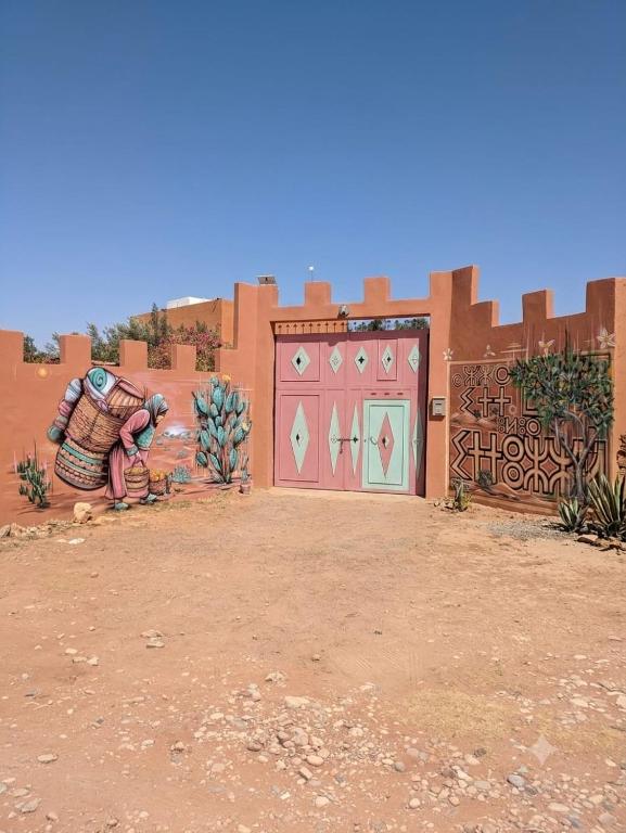 a building with two garage doors in the desert at Quiet house with pool in Aïn Harrouda