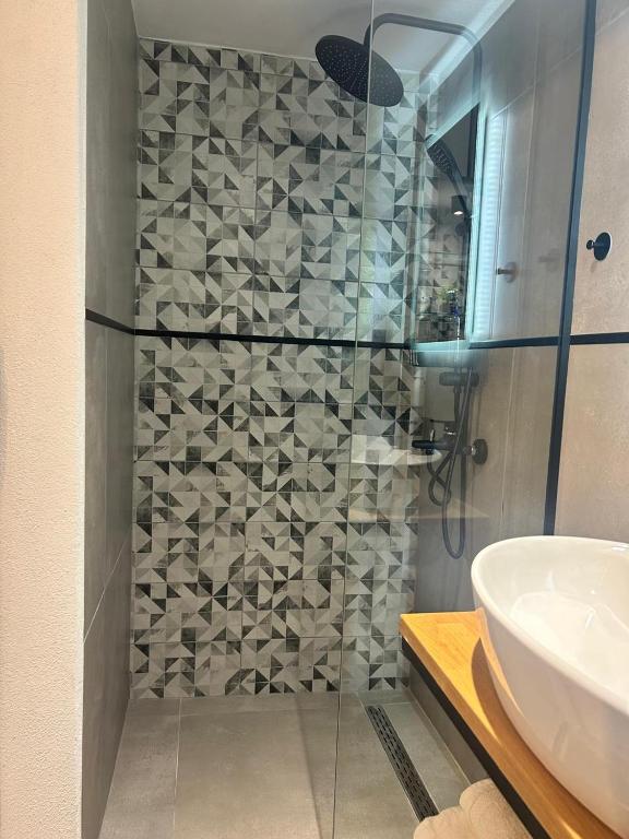 a bathroom with a glass shower with a sink at The Square Point in Komotini