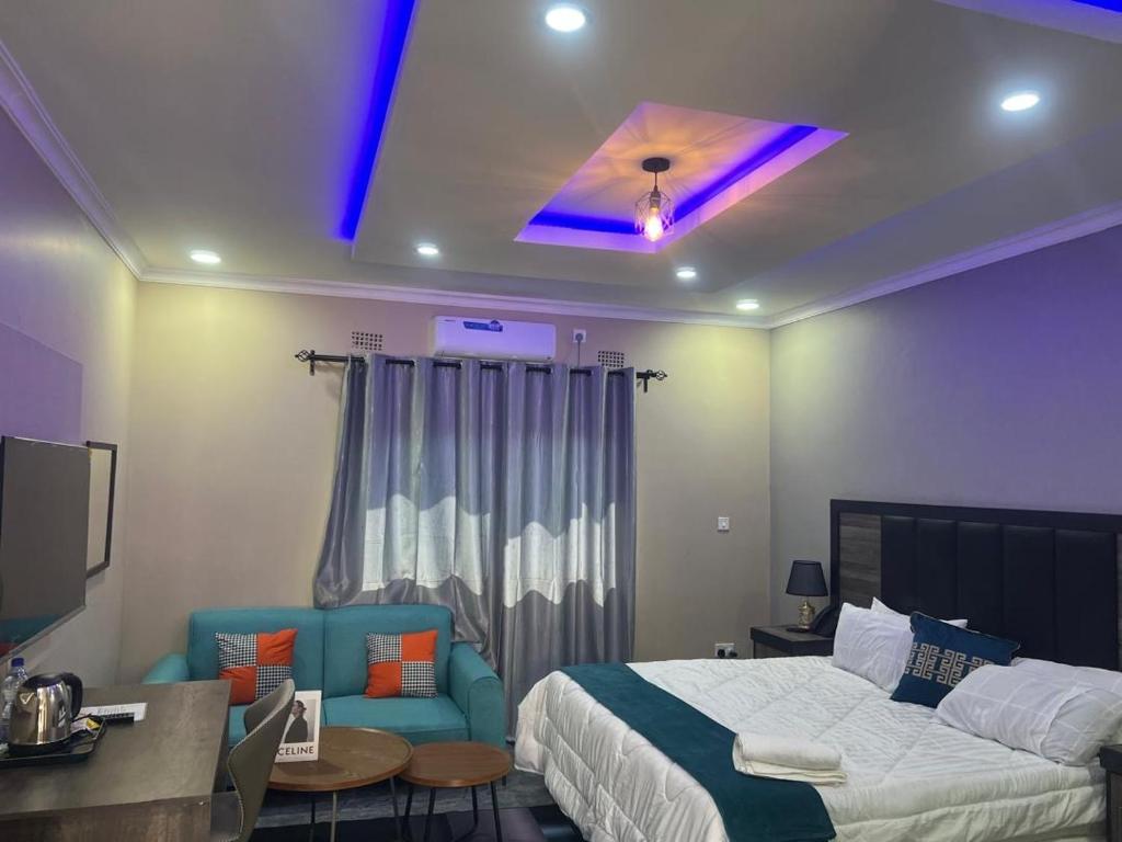 a hotel room with a bed and a desk and a bed and a room at Chaniche Executive Lodge in Ndola