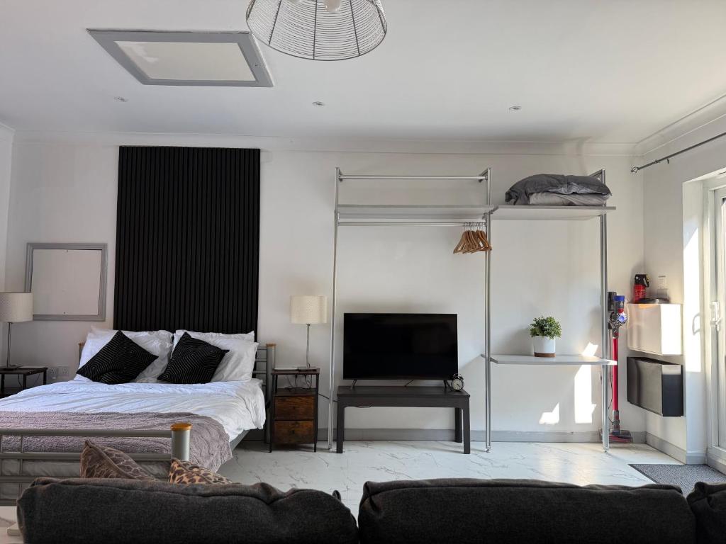 a bedroom with a bed and a tv in it at The Hideaway - Secluded Studio Annexe in Cambourne