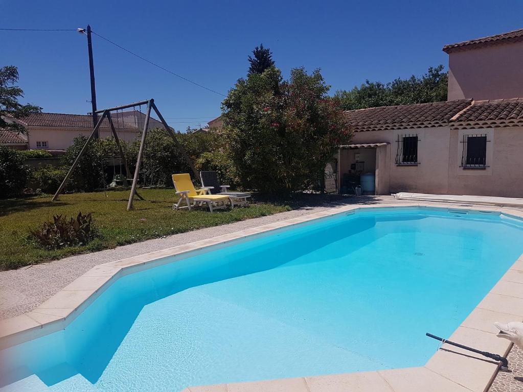 a large blue swimming pool in front of a house at La maison multicolore in Salon-de-Provence