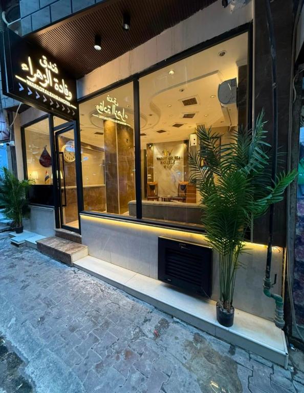 a store front with a potted plant in front of it at فندق وفادة الزهراء in Baghdād