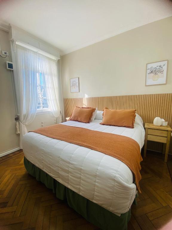 a bedroom with a large bed with two pillows on it at Iconic Obelisco Studio in Buenos Aires