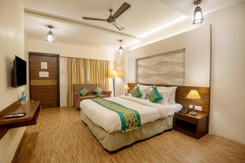 a hotel room with a large bed and a couch at Treebo Five Elements with Swimming Pool in Lonavala
