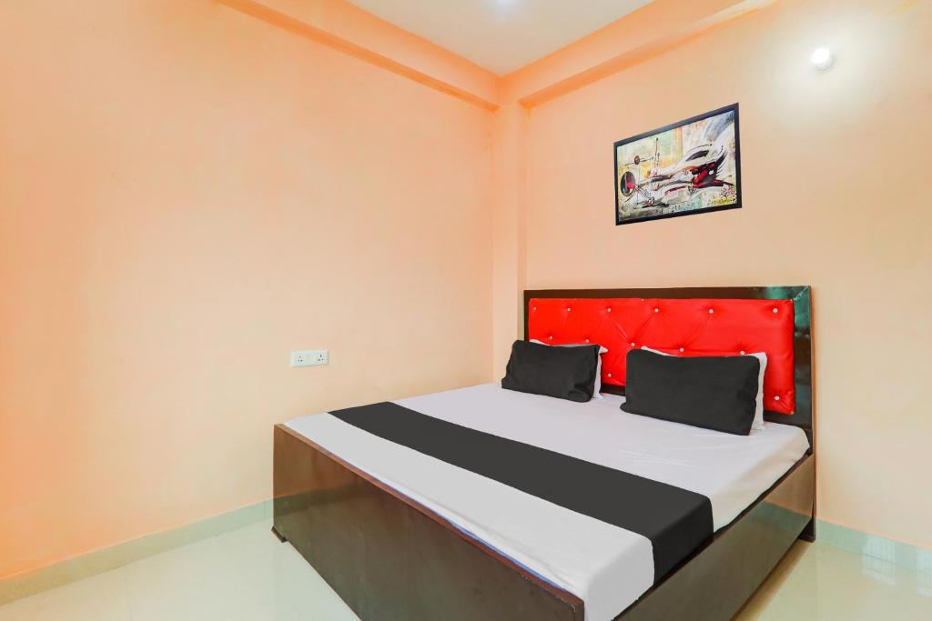 a bedroom with a large bed with a red headboard at Hotel O Luxury Palace in Malīhābād