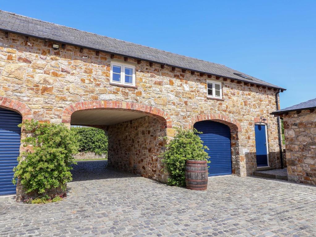 a brick building with two blue garage doors at Pen Y Grisiau in Mold