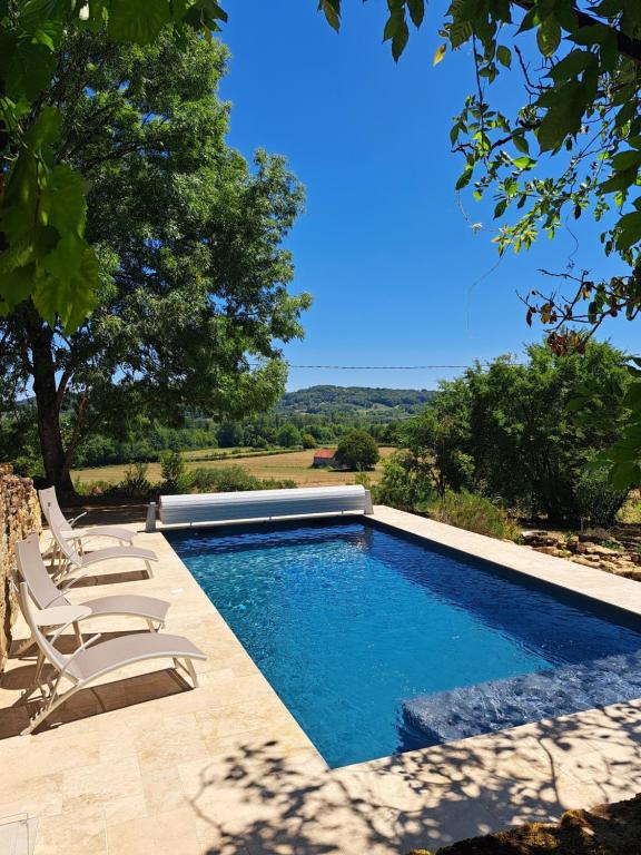 a swimming pool with lounge chairs and a swimming pool at Instant Lot Maison pierre insolite Piscine Nature in Strenquels