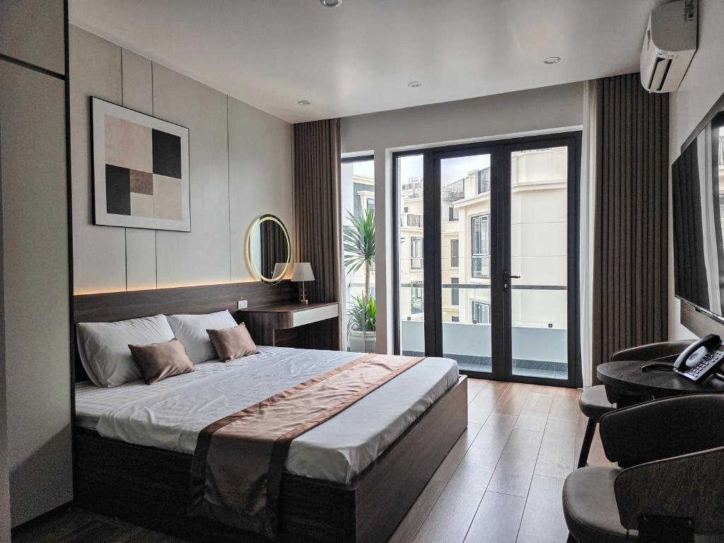 a bedroom with a large bed and a balcony at Tulip Building in Ðông Khê