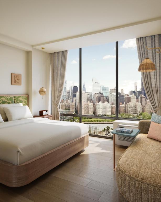a bedroom with a large bed and a large window at Z NYC Hotel in Queens