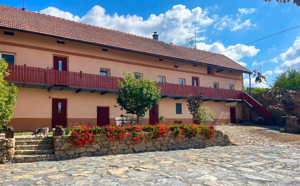 a building with red flowers in front of it at Statek Soví Dvůr in Rabyně