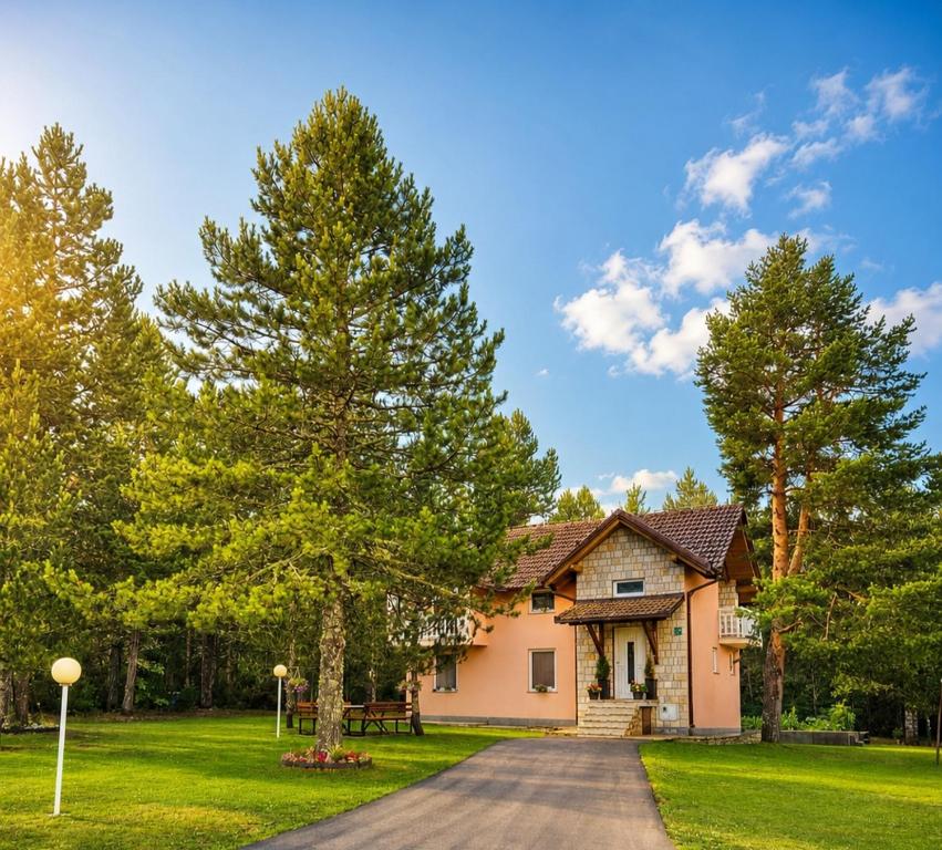 a house with a tree in the yard at Blidinje Bliss in Risovac