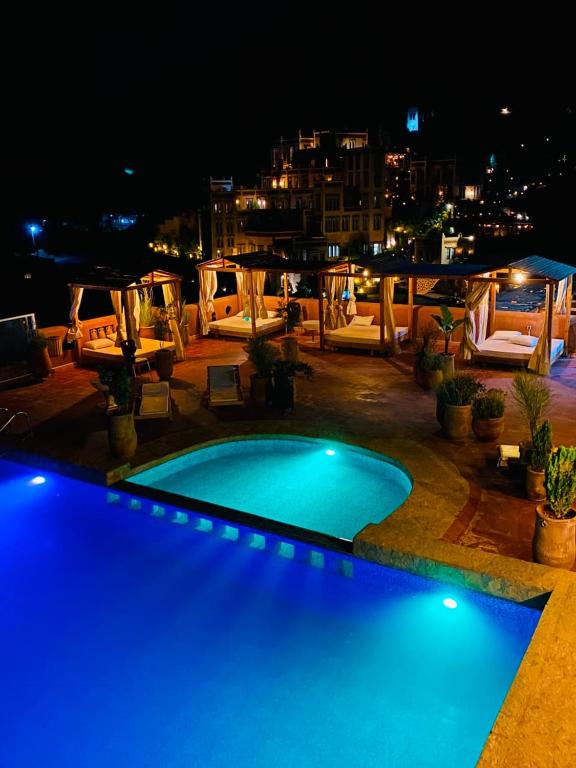 a swimming pool with blue lights on a patio at night at Riad Rihana Dades in Boumalne Dades
