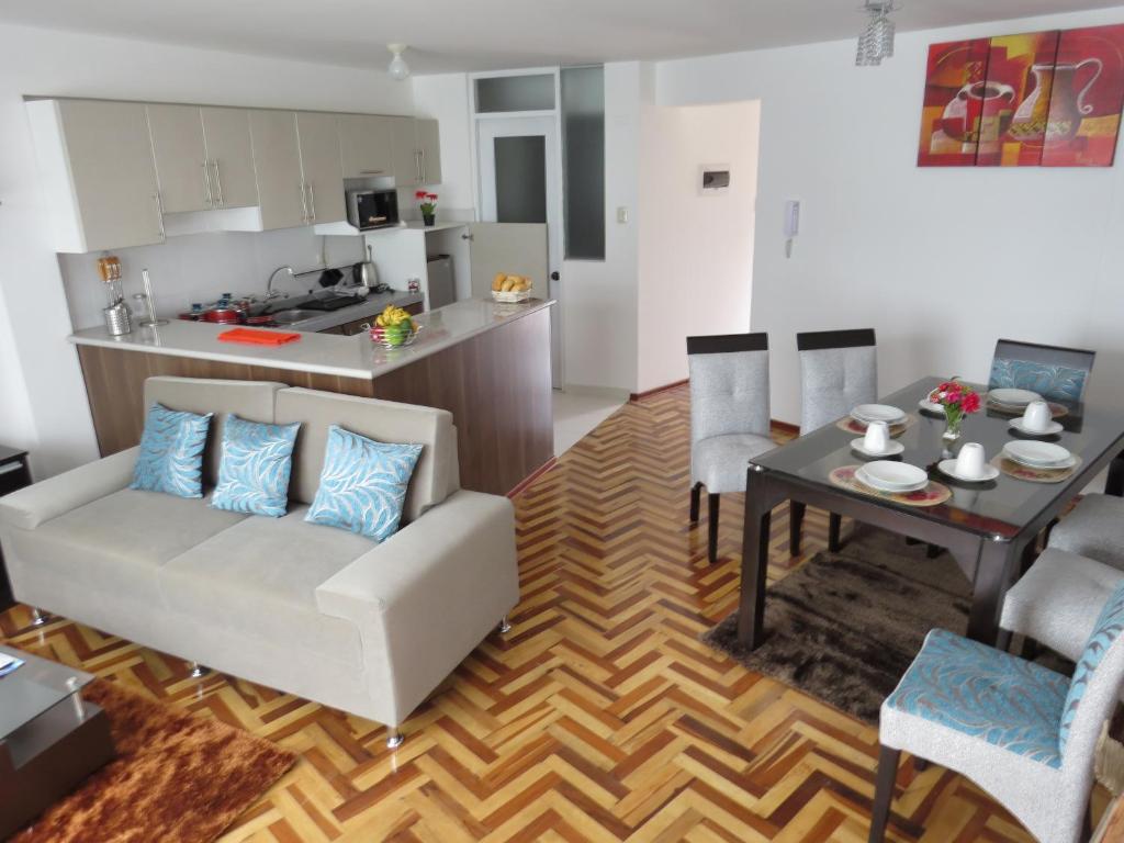 un soggiorno con divano bianco e tavolo di Apartamentos Quewe a Cuzco
