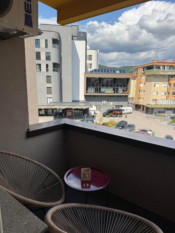 a table and two chairs on a balcony with a view at Capital apartman in Visoko