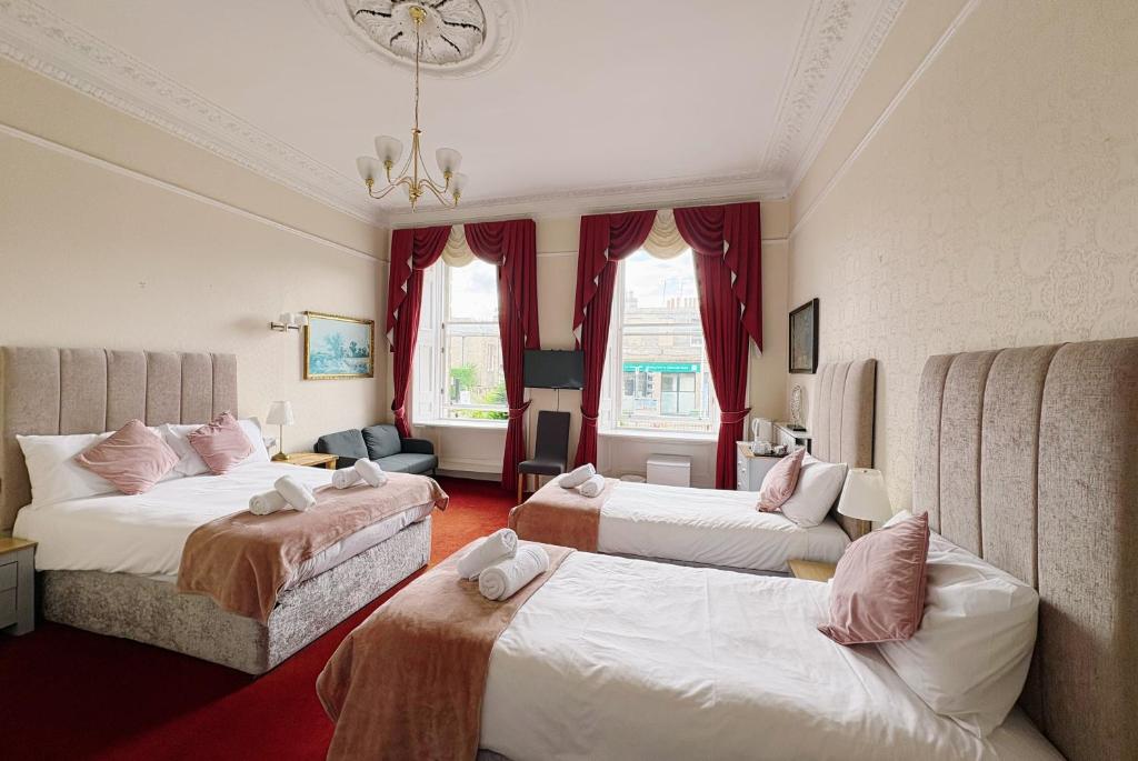 a hotel room with two beds and a couch at Edinburgh full bliss in Edinburgh