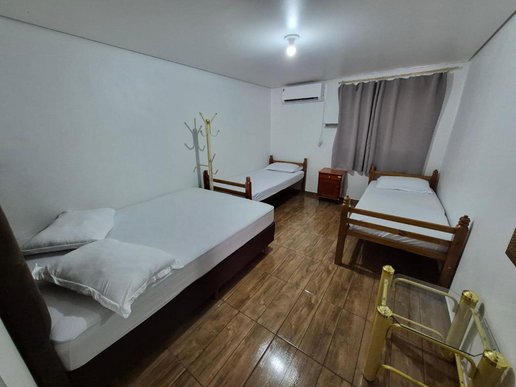 a bedroom with two beds and a window at Pousada Maria in Maravilha
