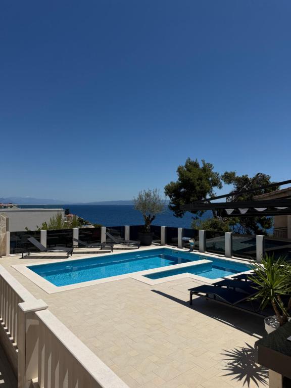 a swimming pool with a view of the ocean at Villa Omazic in Trogir