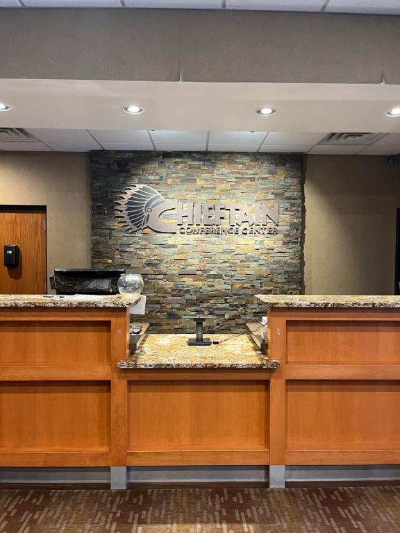 a lobby with a brick wall with a sign on it at Chieftain Conference Center in Carrington