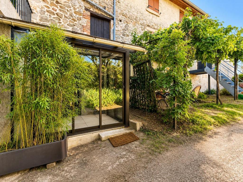 a glass extension of a house with potted plants at Le St Joseph in Vérin