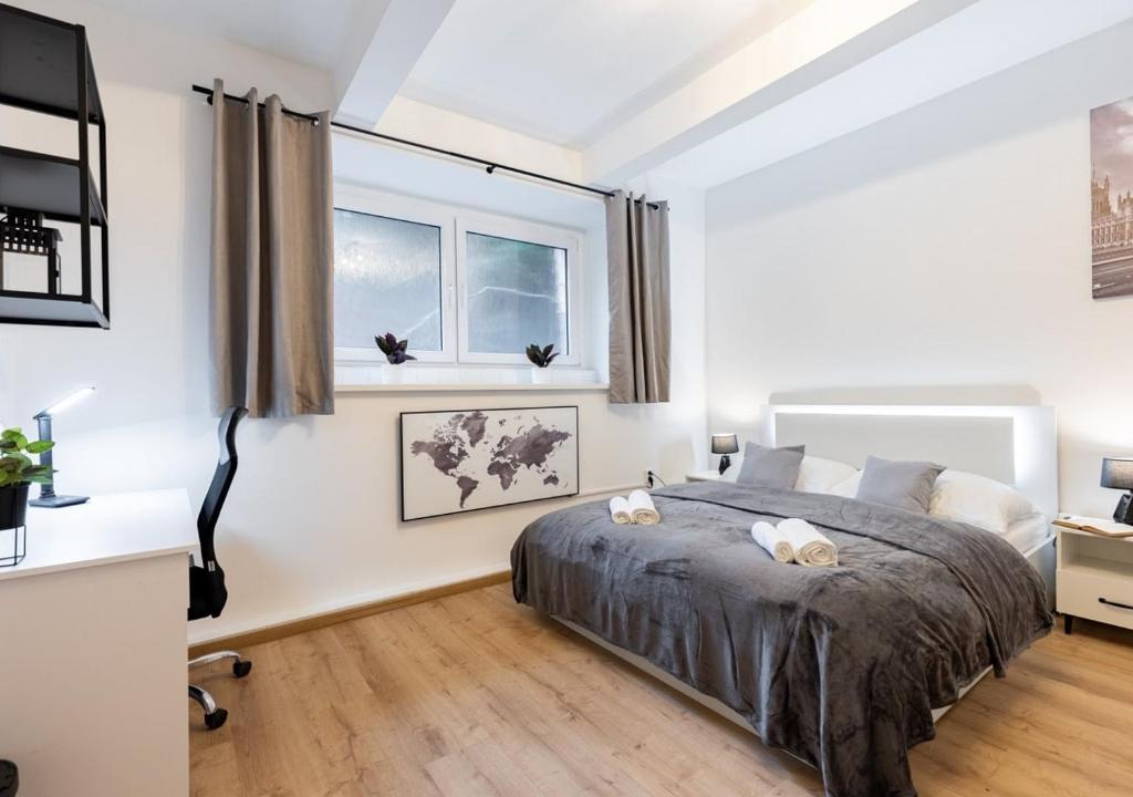 a bedroom with a bed and two windows at Calm Center Modern Apartment in Staré Mesto