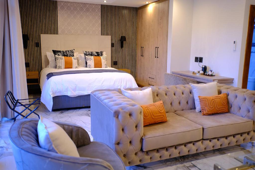 a bedroom with a bed and a couch and a bed at The ATRIUM BOUTIQUE HOTEL in Polokwane