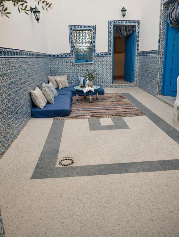 a living room with a blue couch and a table at Dar Sarah in Kelibia