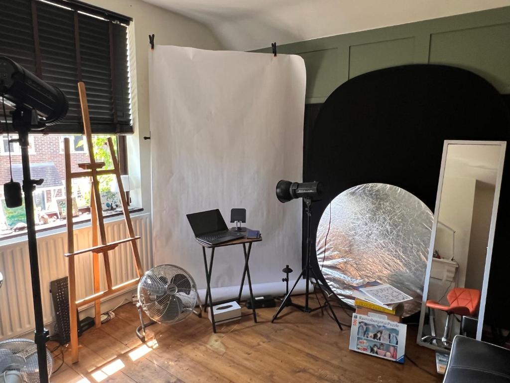 a room with a white curtain and a table with a laptop at Relax in a Creative Art Space in Guildford