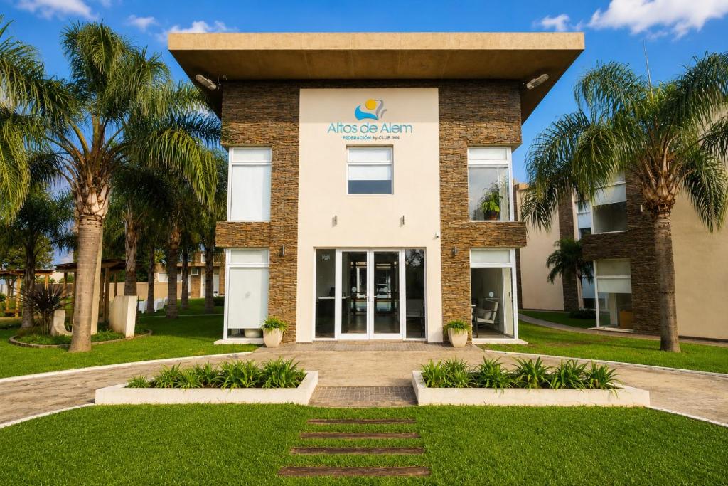 a building with palm trees in front of it at Altos de Alem in Federación