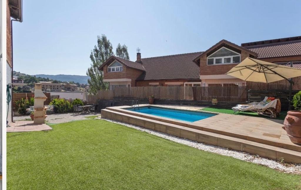a backyard with a swimming pool and a house at El Rinconcito de La Suiza in Robledo de Chavela