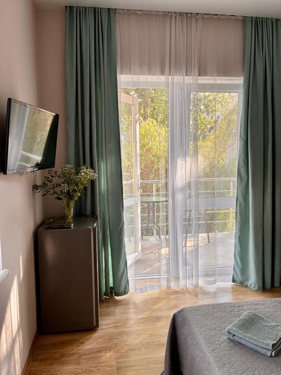 a bedroom with a bed and a sliding glass door at Мини отель Семейного типа. in Zatoka
