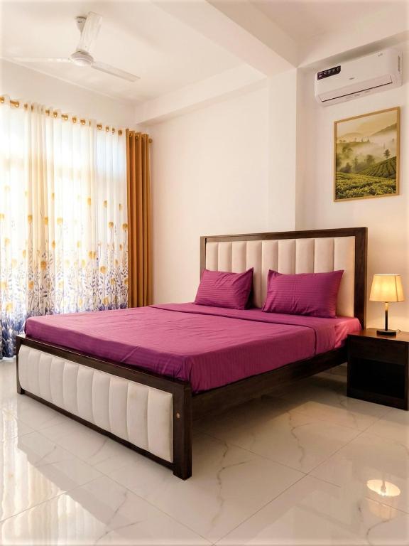 a bedroom with a large bed with purple sheets at Papa's Resort Dunhinda in Hinnarangahakumbura