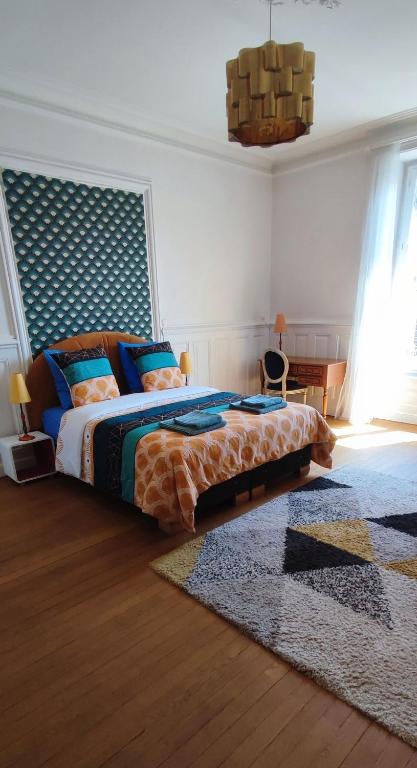a bedroom with a large bed and a rug at Particulier & Pro - 4 chambres - 8 pers - Jaude avec parking privée in Clermont-Ferrand