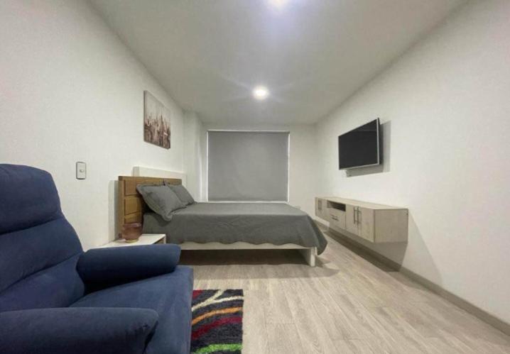 a bedroom with a bed and a couch and a tv at Imperial house in Envigado