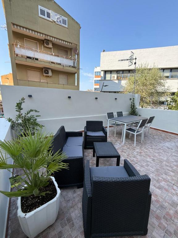 a patio with tables and chairs and a table on a building at Civico 8 Apartment in Sassari