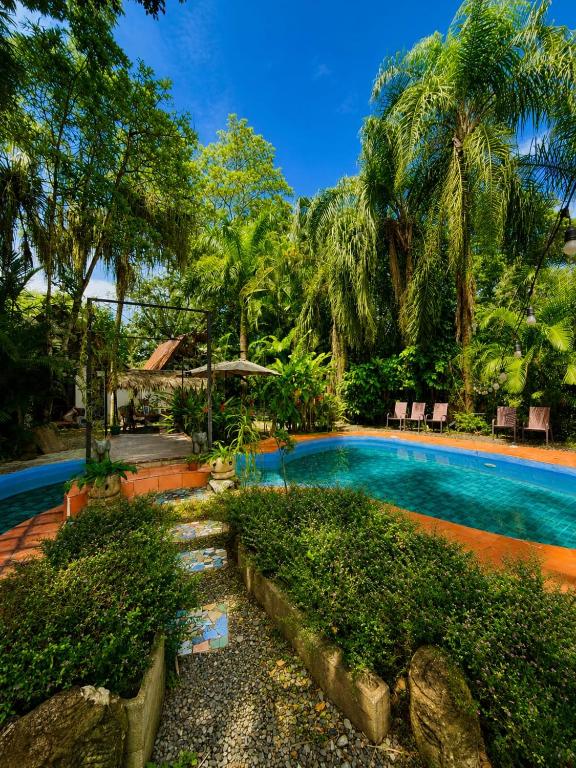 a swimming pool in a resort with palm trees at Hotel Mandacarú Puerto Viejo in Puerto Viejo