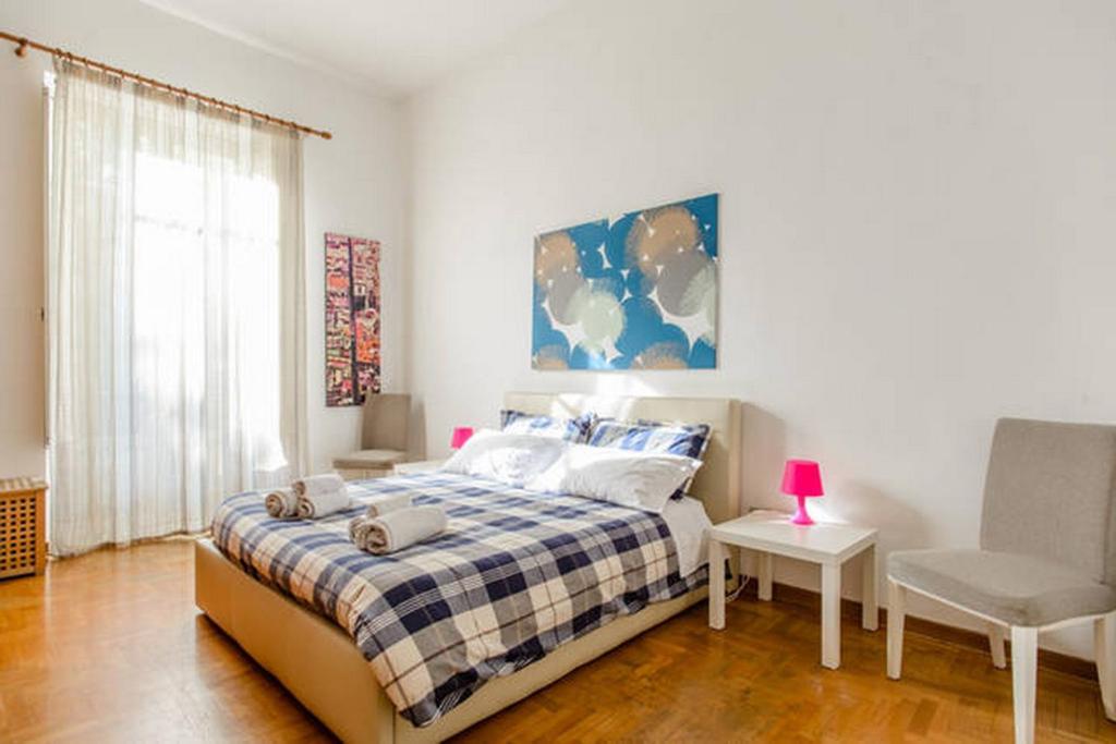 um quarto com uma cama e uma cadeira em Casa Michelangelo em Nápoles