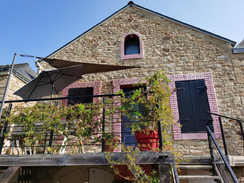 a brick house with a black door and windows at La maison Kerserho in Plouhinec