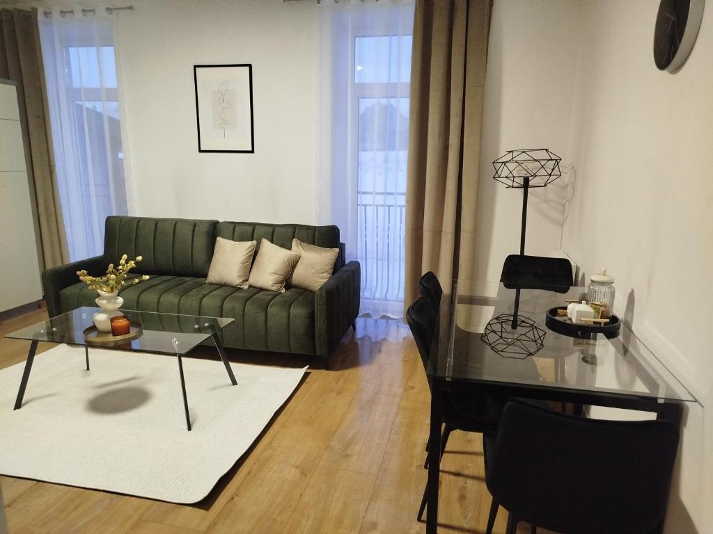 a living room with a green couch and a glass table at Apartmán VERDE in Suchá Hora