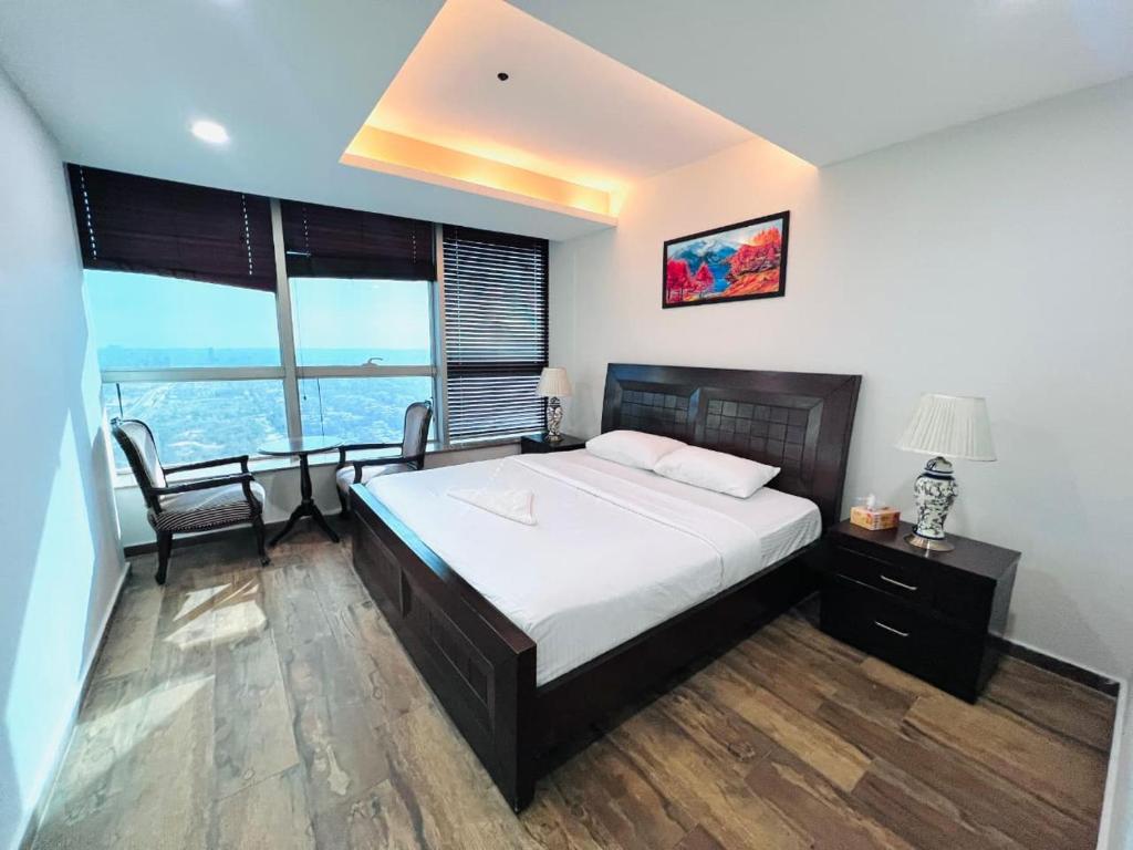 a bedroom with a large bed and a large window at Penta Prestige Hotel Apartments DHA Lahore - LMY Hospitality in Lahore