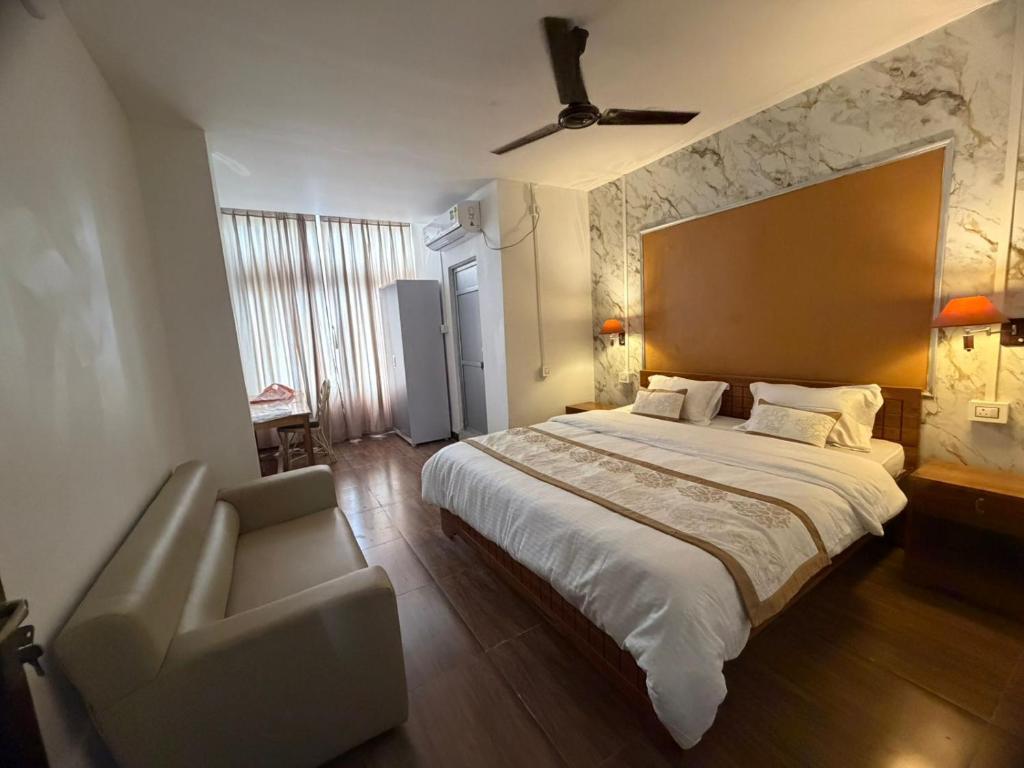 a bedroom with a large bed and a chair at Kesang Stay in Diphu