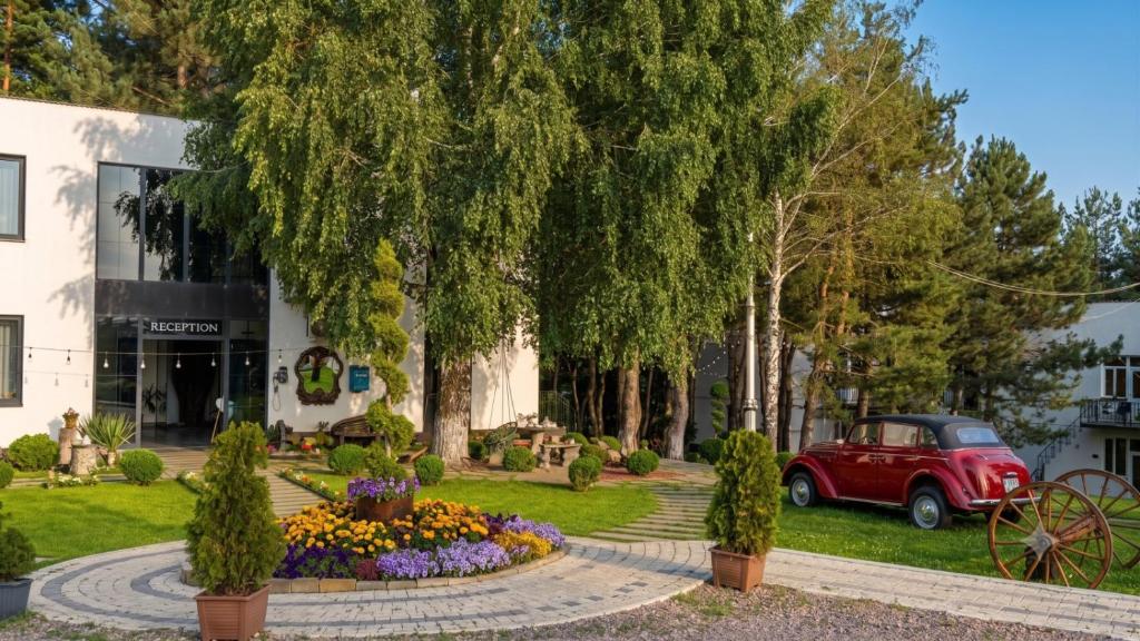 a red car parked in front of a building at Sochi Resort-Pine Garden Boutique Hotel and Pool Stepanavan in Stepʼanavan